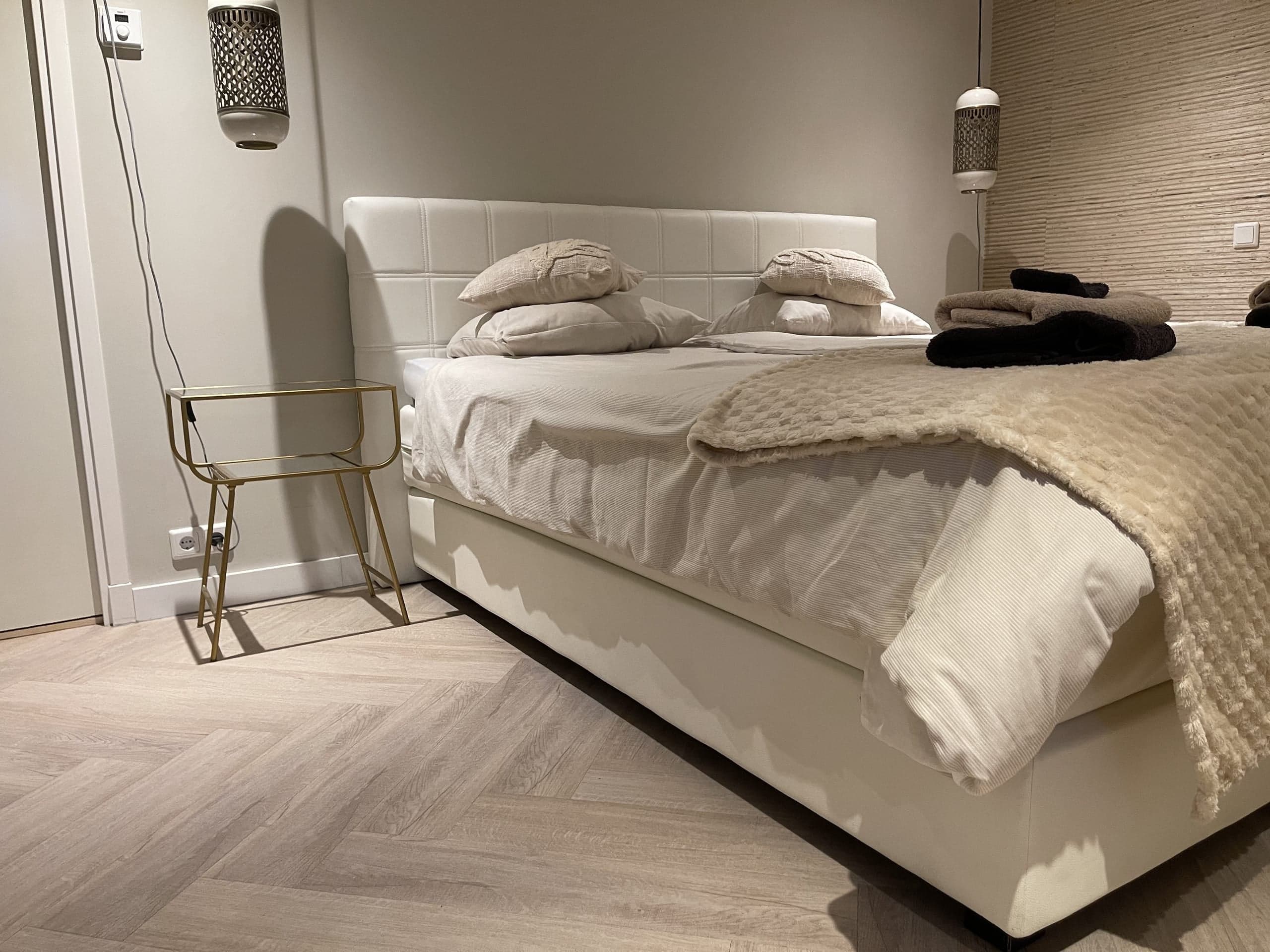 Bed en wandlamp in de slaapkamer van Oester